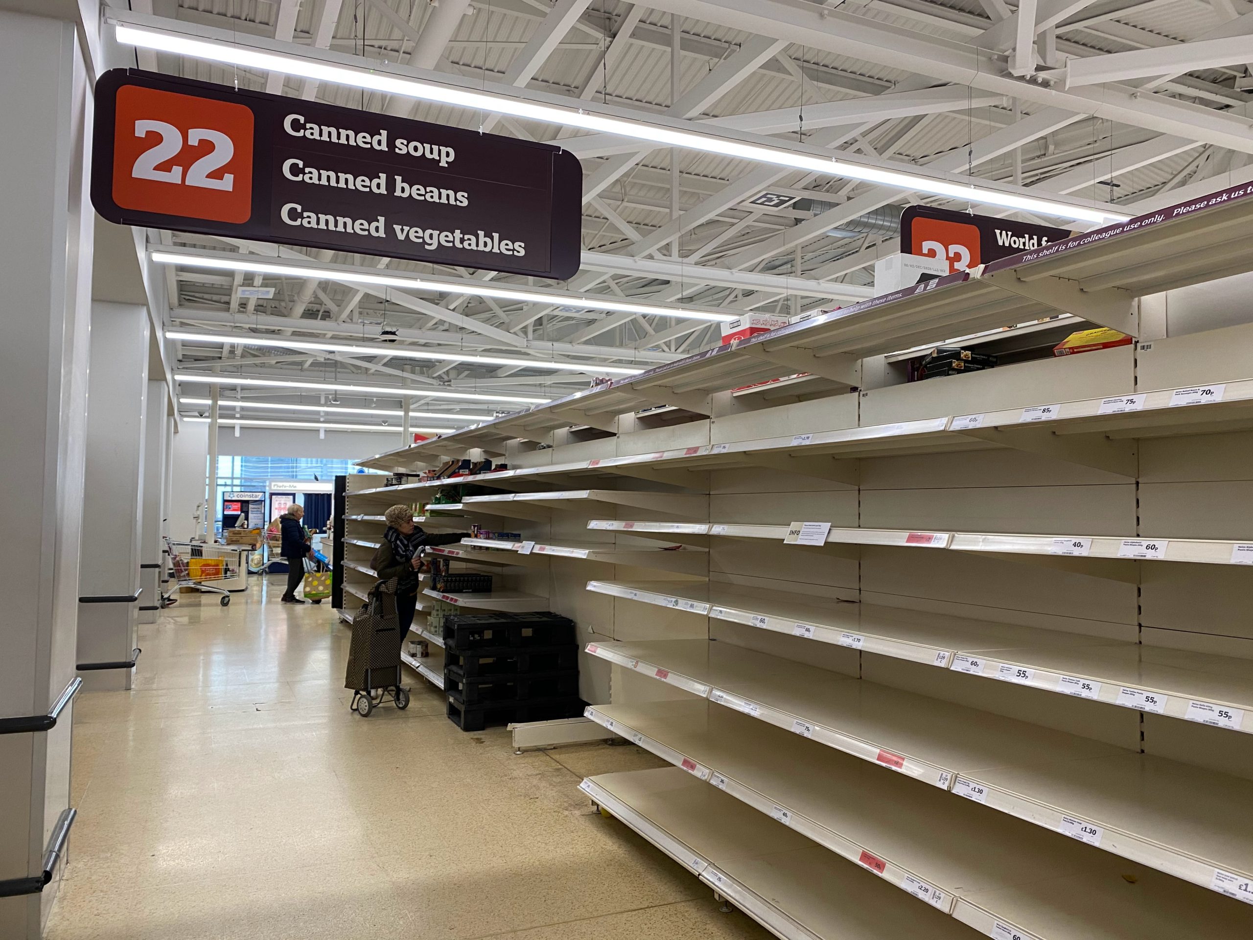 Aisle in supermarket with near empty shelves